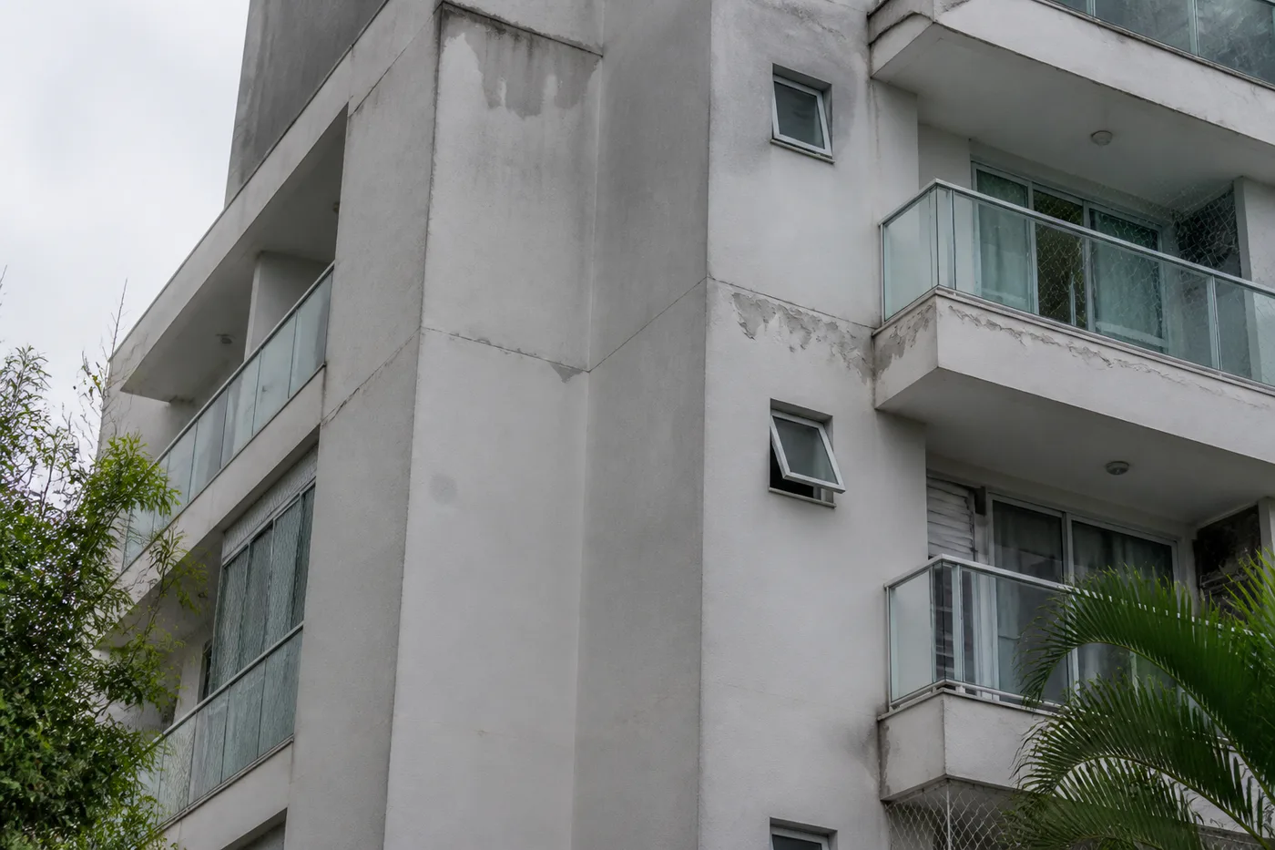 Fachada de condomínio com sinais de umidade e desgaste